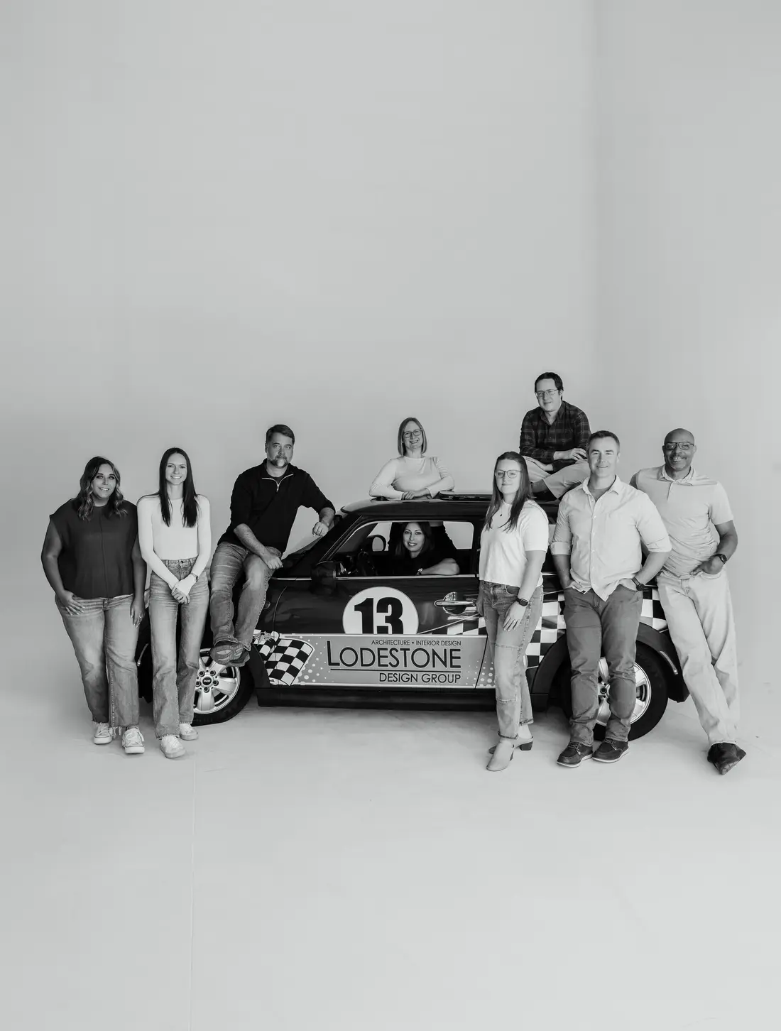 A race team posed around their car